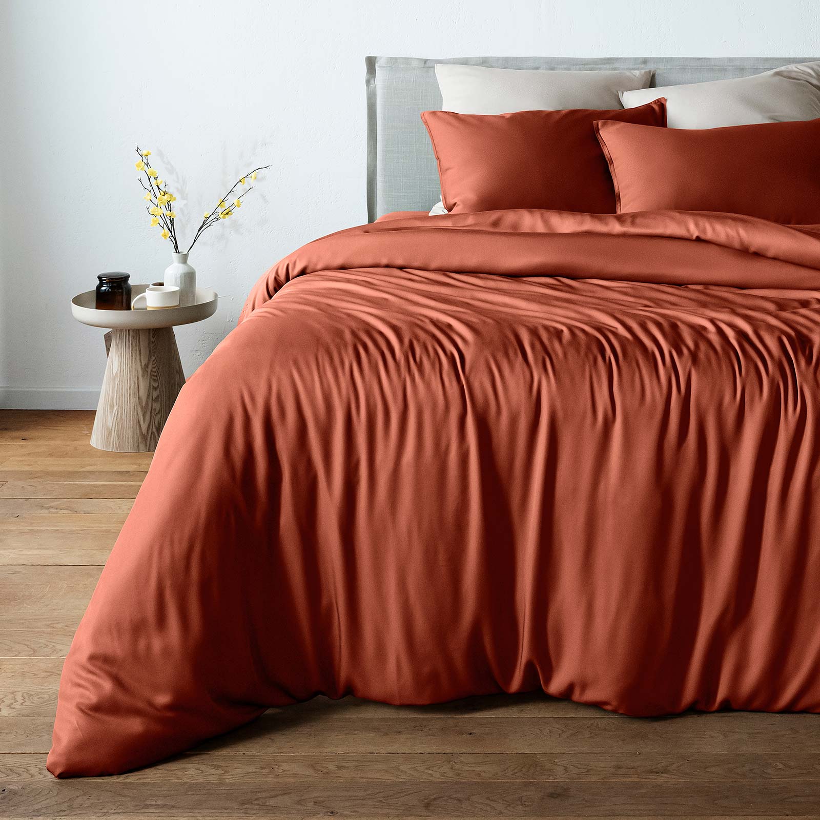 bambaw cozy terracotta duvet cover and pillows on a bed with a neutral background