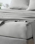 bambaw cozy bamboo bed sheets close up on a bed with fitted sheets and pillows in ight grey colour